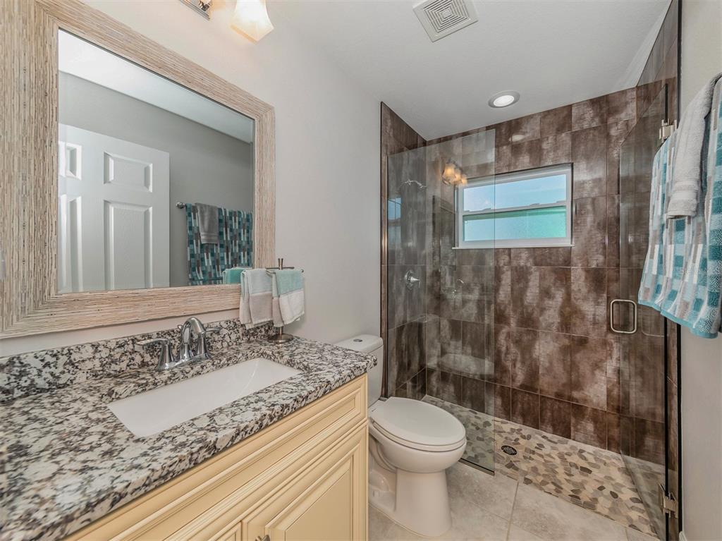 236 Holly Road Venice, FL 34293 - Photo 28 of 88 a bathroom with a granite countertop sink a toilet and shower