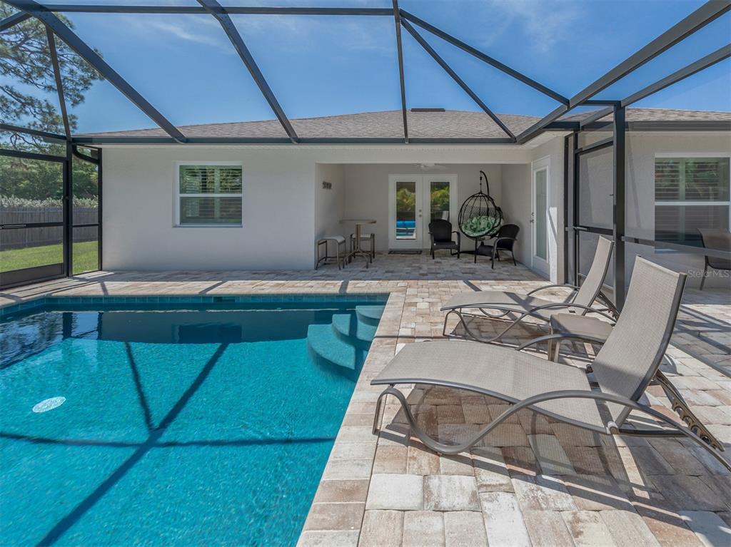 236 Holly Road Venice, FL 34293 - Photo 32 of 88 a view of a patio with table and chairs under an umbrella