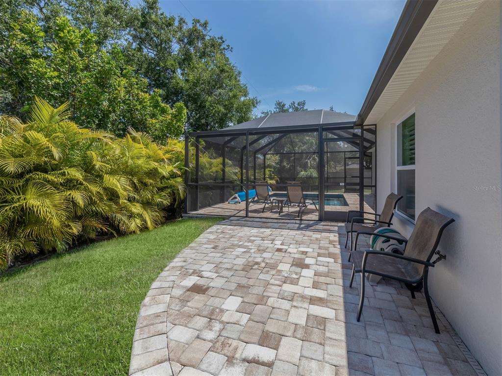 236 Holly Road Venice, FL 34293 - Photo 36 of 88 a view of a patio with table and chairs under an umbrella