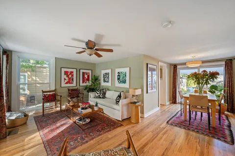 a dining room with furniture potted plants and wooden floor