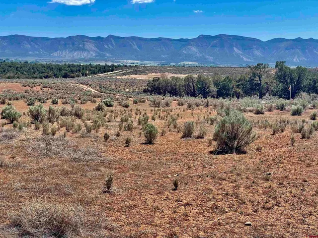 a view of a large mountain with a mountain in the background