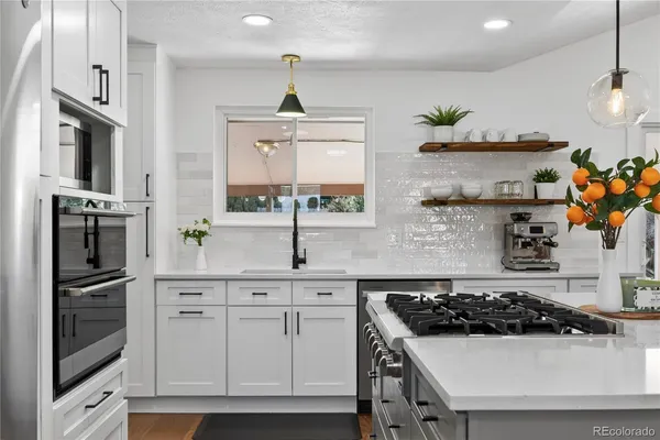 a kitchen with stainless steel appliances a sink a stove and a refrigerator