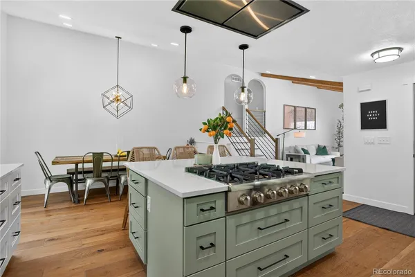 a kitchen with a stove and a wooden floor