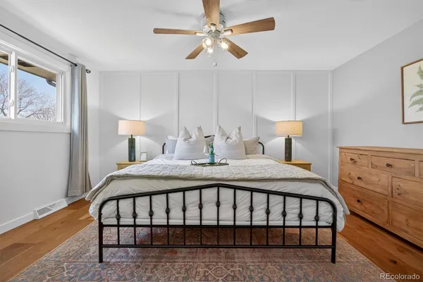 a bedroom with a bed a lamp and fan
