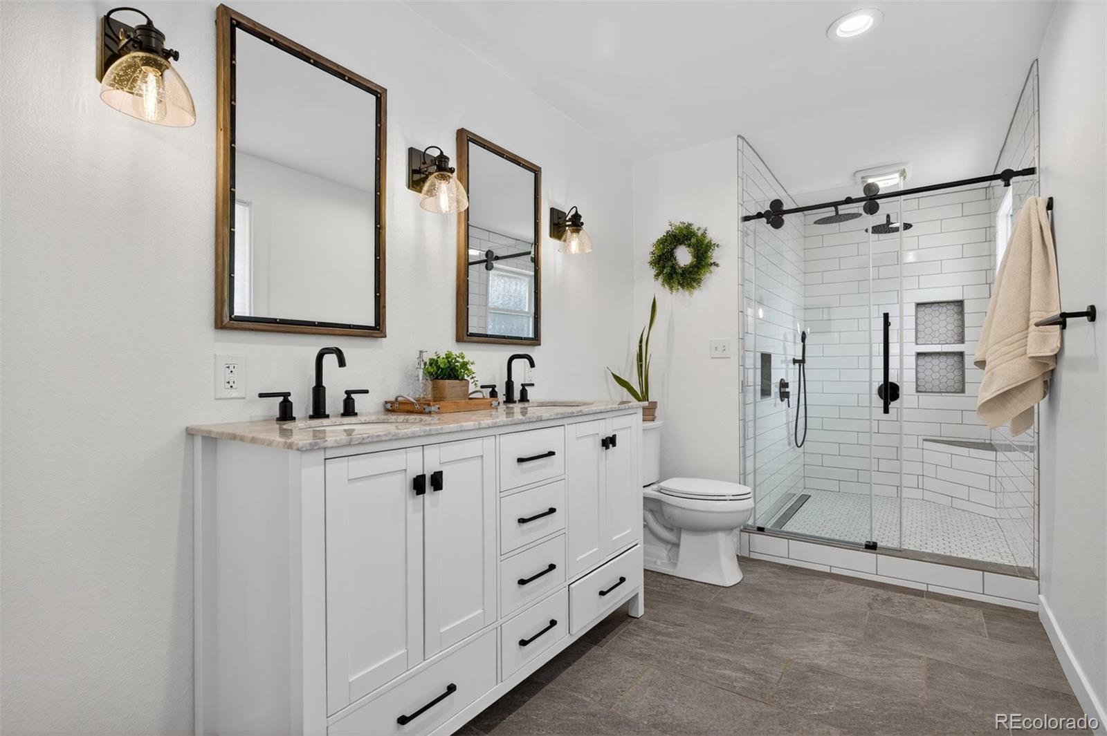 5915 South Birch Way Centennial, CO 80121 - Photo 10 of 22 a bathroom with a double vanity sink toilet and shower