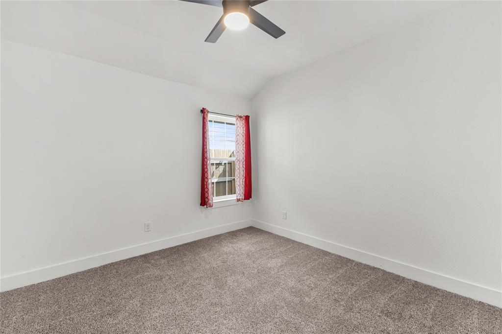 101 Ross Street Sulphur Springs, TX 75482 - Photo 17 of 30 Carpeted spare room featuring lofted ceiling and a ceiling fan