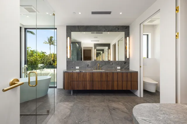 a bathroom with a granite countertop sink mirror and shower