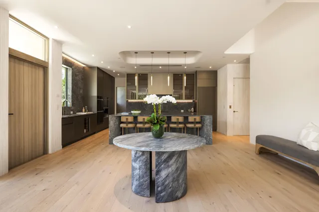 a kitchen with stainless steel appliances granite countertop a table chairs sink and cabinets