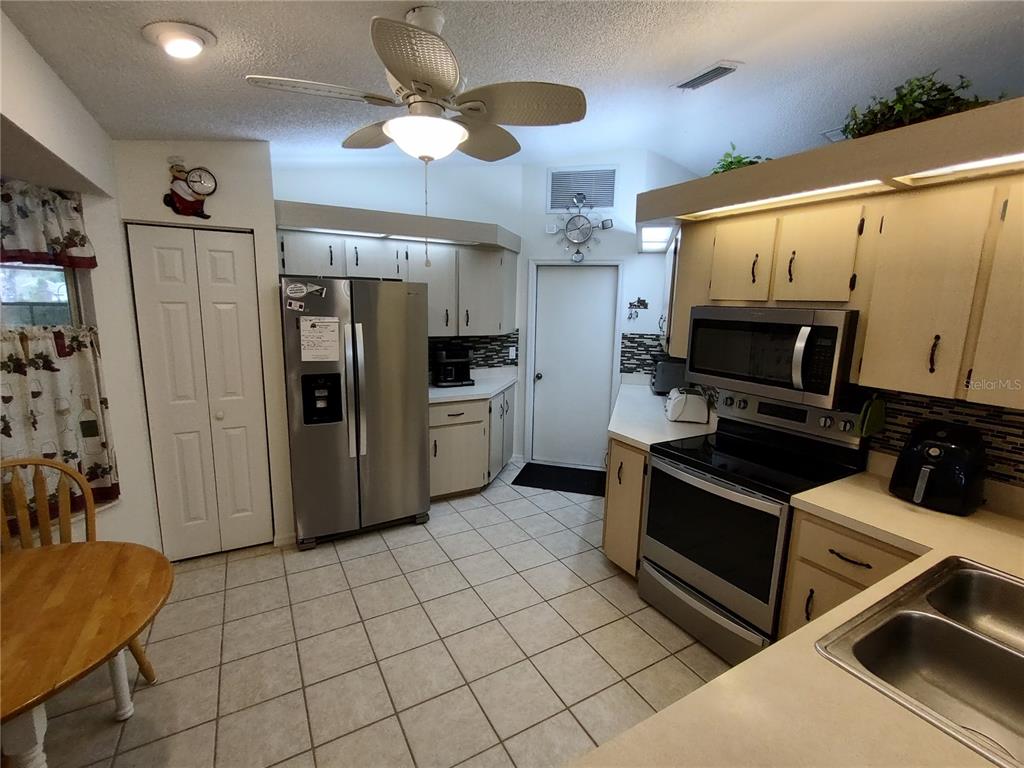 8274 Southwest 116th Street Ocala, FL 34481 - Photo 12 of 30 a kitchen with stainless steel appliances a stove refrigerator and microwave
