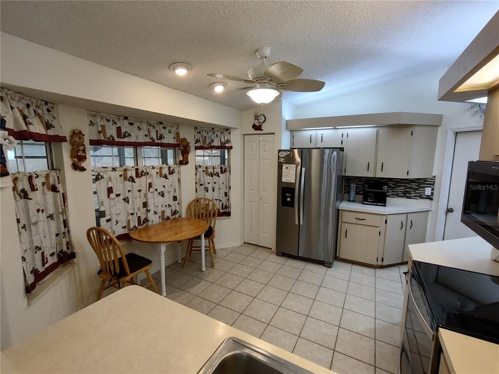 8274 Southwest 116th Street Ocala, FL 34481 - Photo 13 of 30 a kitchen with stainless steel appliances a refrigerator sink and cabinets