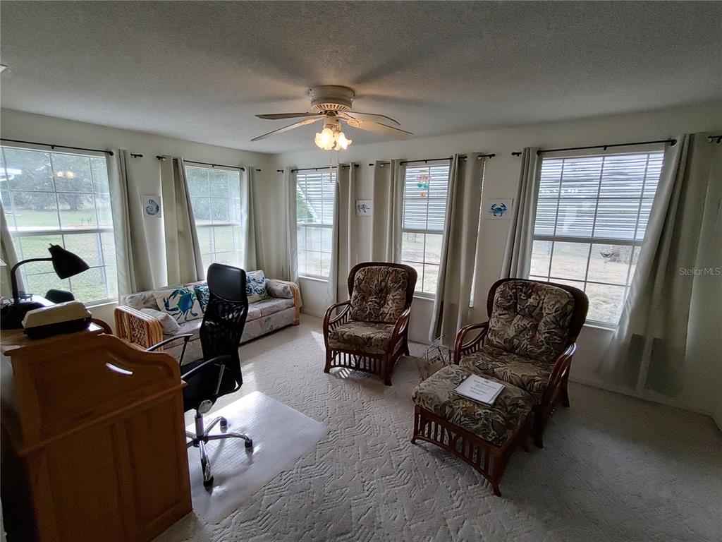 8274 Southwest 116th Street Ocala, FL 34481 - Photo 14 of 30 a living room with furniture ceiling fan and a window