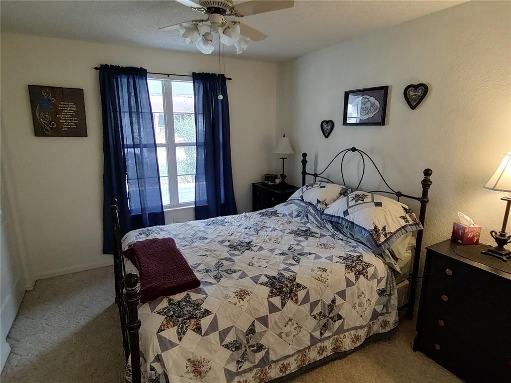8274 Southwest 116th Street Ocala, FL 34481 - Photo 17 of 30 a bedroom with a bed and a chandelier