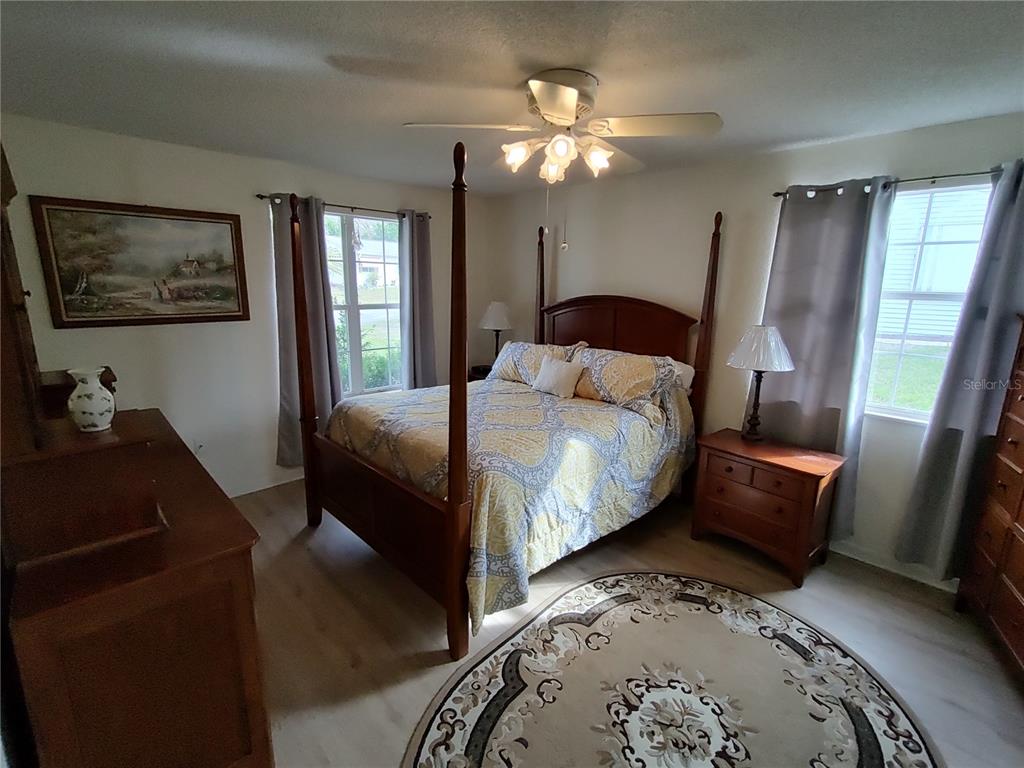 8274 Southwest 116th Street Ocala, FL 34481 - Photo 20 of 30 a bedroom with a bed and wooden floor