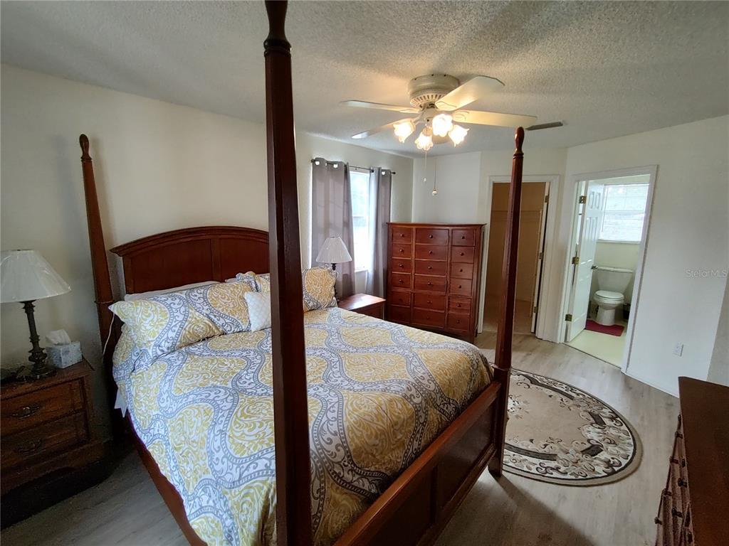 8274 Southwest 116th Street Ocala, FL 34481 - Photo 21 of 30 a bedroom with a bed and a chandelier