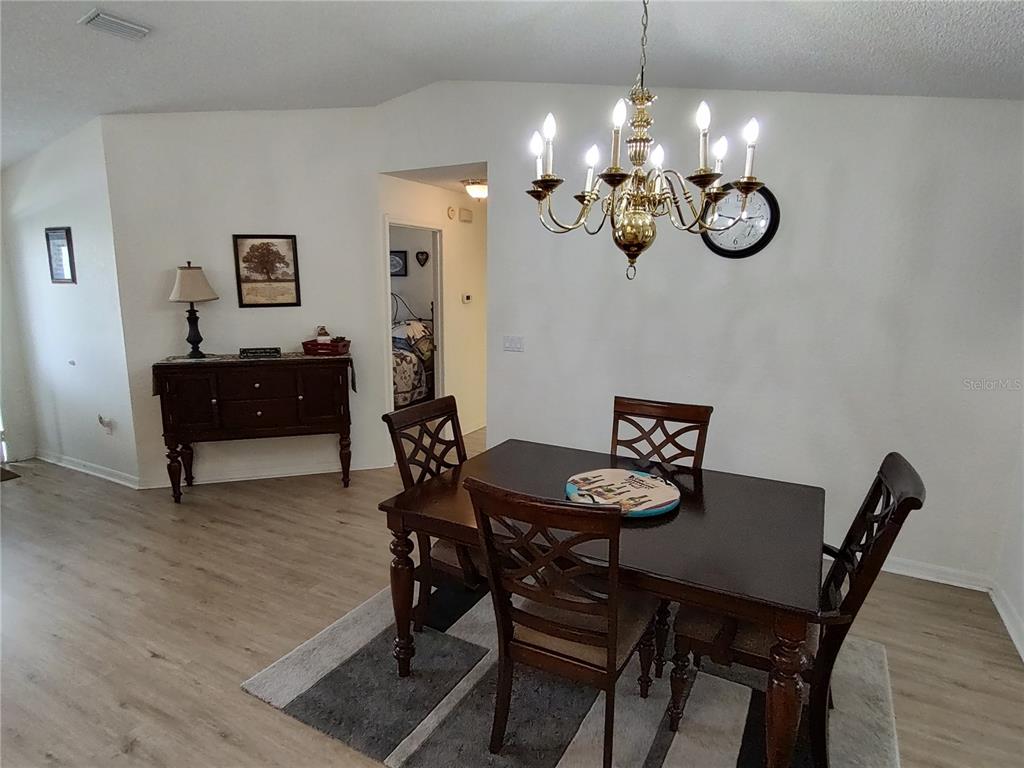 8274 Southwest 116th Street Ocala, FL 34481 - Photo 10 of 30 a view of a dining room with furniture and chandelier