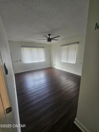 a view of an empty room with wooden floor