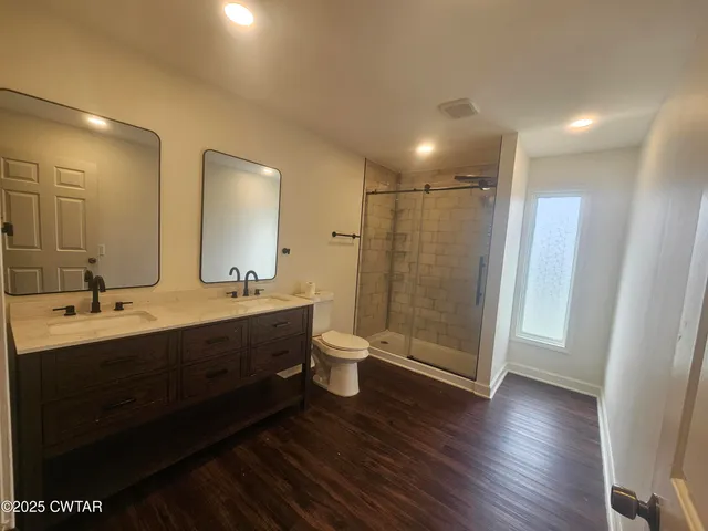 a bathroom with a double vanity sink toilet and shower