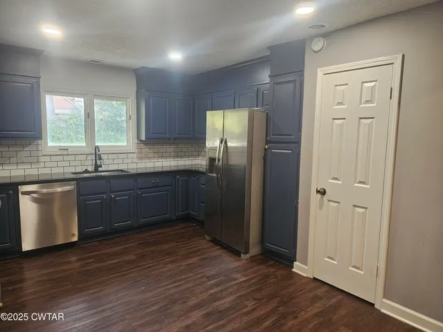 a kitchen with stainless steel appliances granite countertop a refrigerator and a sink