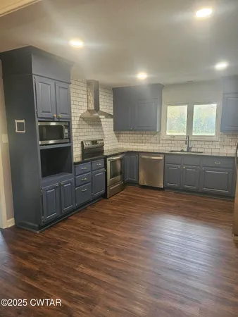 a kitchen with stainless steel appliances granite countertop a refrigerator and a sink