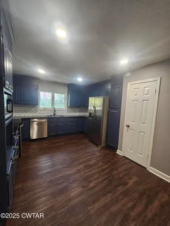 a view of a kitchen with a sink and a refrigerator