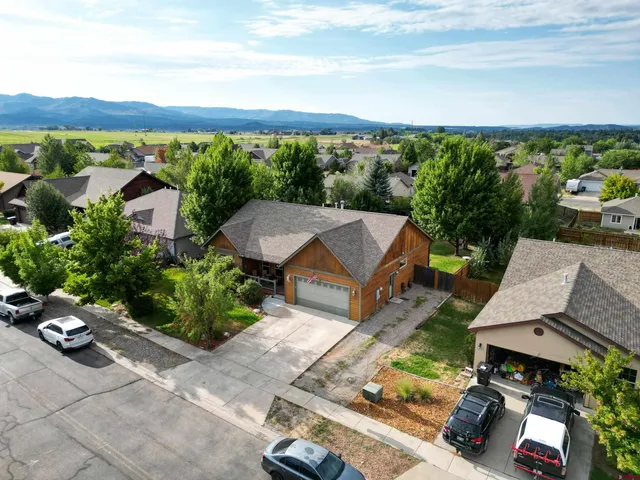 aerial view of a house with balcony and trees al around