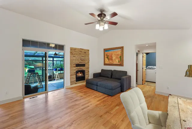 a living room with furniture and a flat screen tv with wooden floor