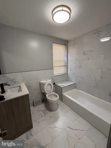 a bathroom with a toilet a sink and bathtub