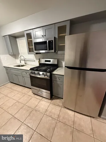 a kitchen with stainless steel appliances a refrigerator sink and microwave