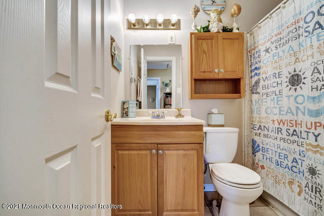 39 Kingsley Way Freehold, NJ 07728 - Photo 20 of 24 a bathroom with a sink a toilet and shower curtain