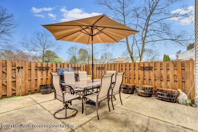 39 Kingsley Way Freehold, NJ 07728 - Photo 21 of 24 a view of a patio with table and chairs under an umbrella