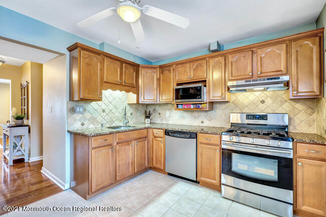 39 Kingsley Way Freehold, NJ 07728 - Photo 8 of 24 a kitchen with stainless steel appliances granite countertop a stove top oven a sink dishwasher and a microwave oven on the blue kitchen countertops