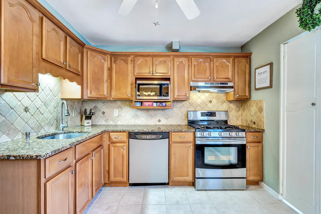 39 Kingsley Way Freehold, NJ 07728 - Photo 9 of 24 a kitchen with stainless steel appliances granite countertop a stove sink and cabinets