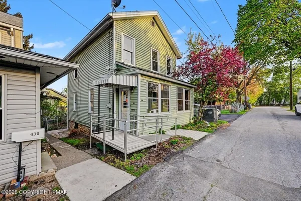 a front view of a house with a yard and outdoor seating