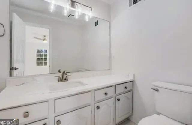 a bathroom with a sink a toilet and vanity
