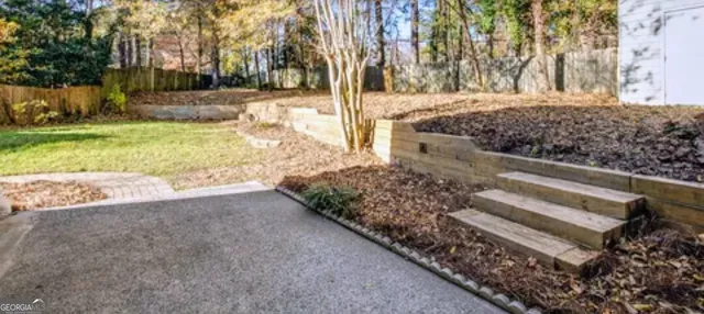 a view of a yard with wooden fence