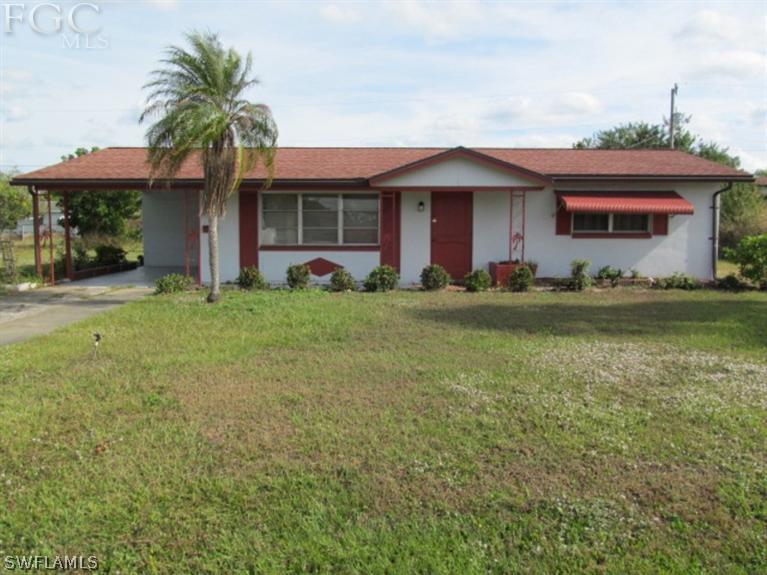 106 Georgia Road Lehigh Acres, FL 33936 - Photo 1 of 14 a view of a house with garden and yard