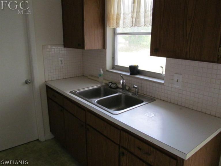 106 Georgia Road Lehigh Acres, FL 33936 - Photo 11 of 14 a kitchen with a sink and cabinets