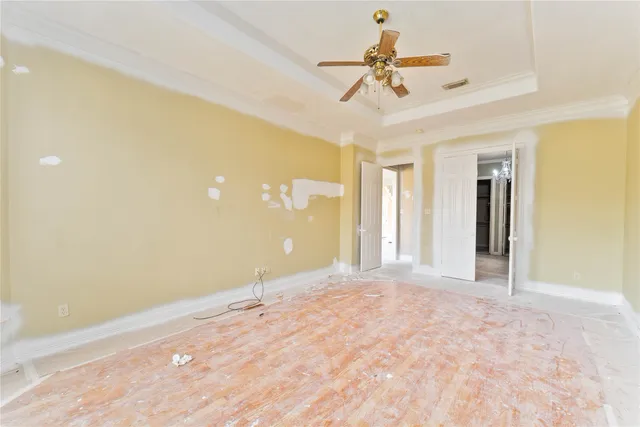 a view of a big room with a ceiling fan and a window