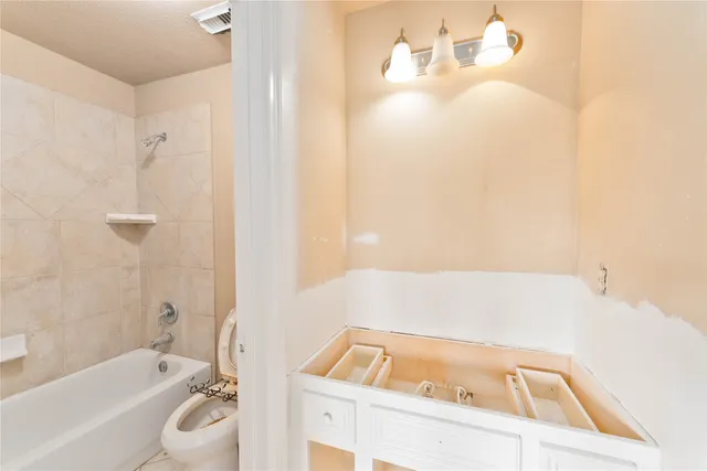 a bathroom with a tub a sink and toilet