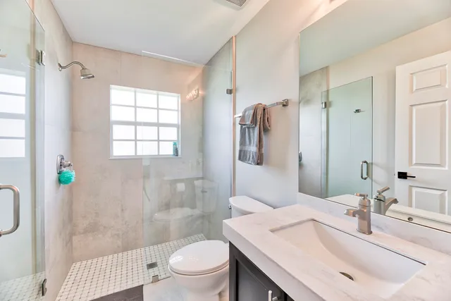 a bathroom with a sink toilet and shower