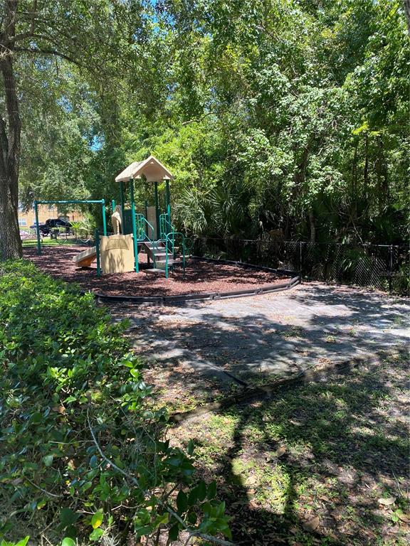 404 Summit Ridge Place, Unit 302 Longwood, FL 32779 - Photo 12 of 13 a backyard of a house with table and chairs