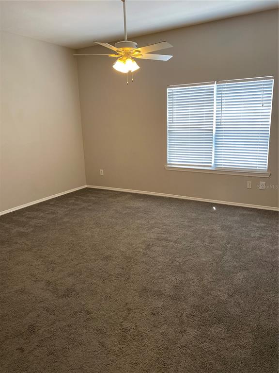 404 Summit Ridge Place, Unit 302 Longwood, FL 32779 - Photo 6 of 13 an empty room with windows and chandelier fan