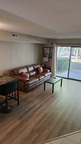 a living room with furniture and a wooden floor