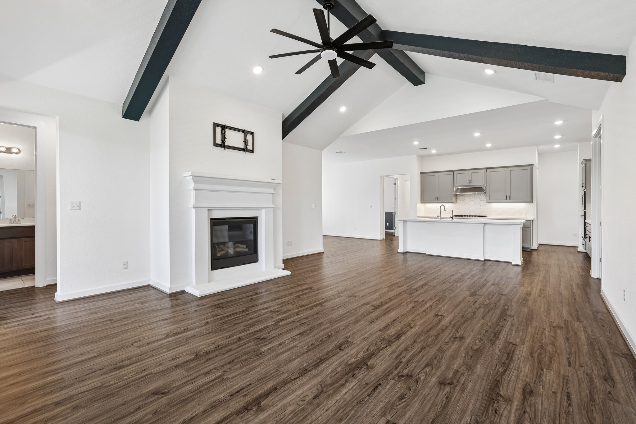 317 Independence Drive Kyle, TX 78640 - Photo 14 of 40 a view of a room with a ceiling fan hardwood floor and a kitchen
