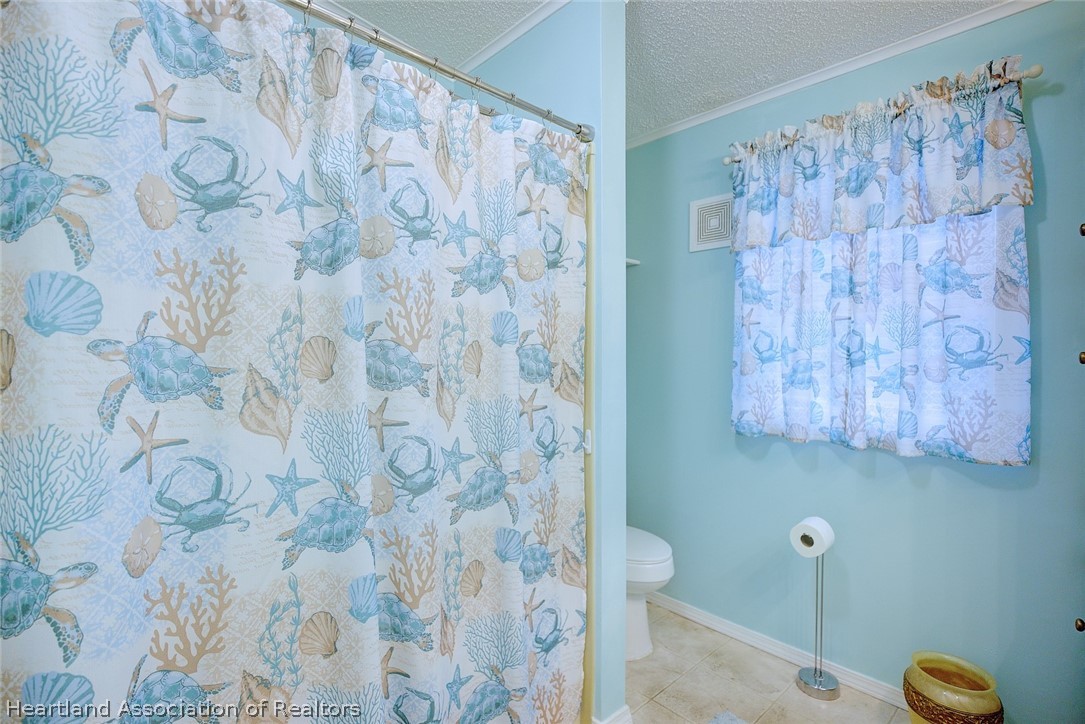 2702 Rodney Street Sebring, FL 33872 - Photo 15 of 33 a bathroom with a shower curtain and a blue curtain