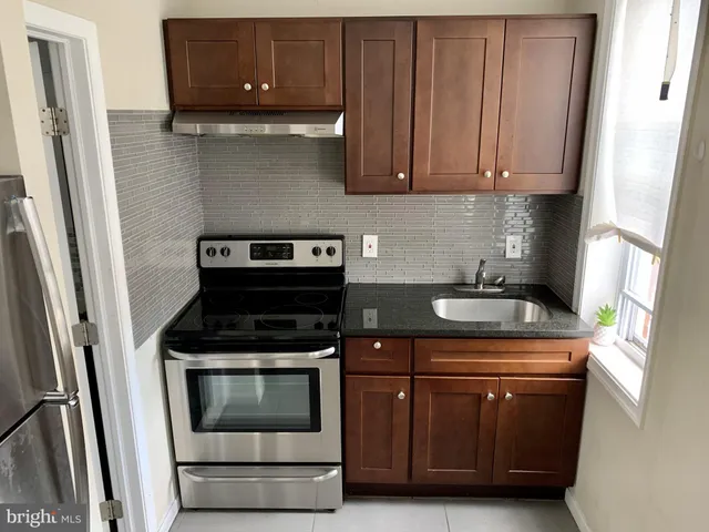 a kitchen with stainless steel appliances granite countertop a stove a microwave and a refrigerator