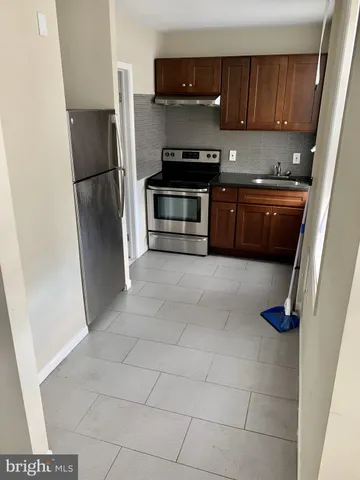 a kitchen with stainless steel appliances a stove a refrigerator and a sink