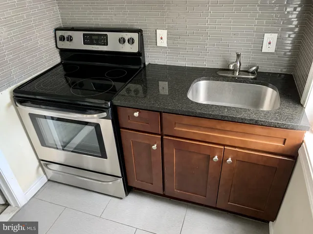 a kitchen with granite countertop a sink and a stove