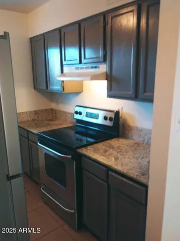 a bathroom with a granite countertop toilet a sink and mirror
