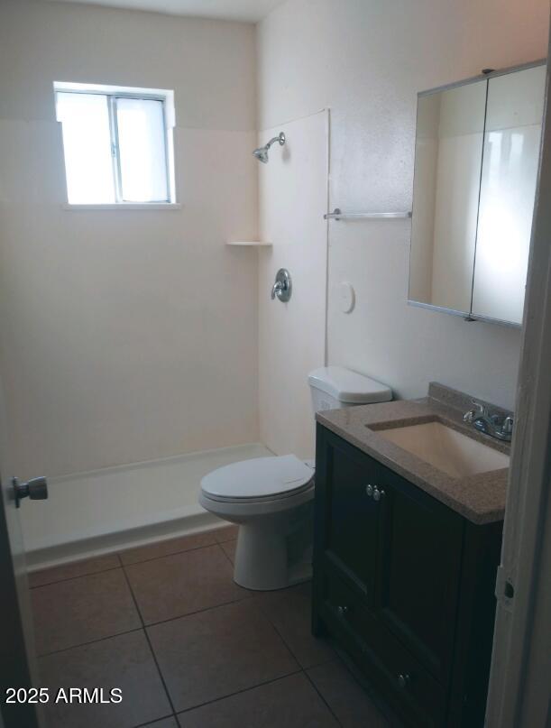 1345 East Campbell Avenue, Unit 7 Phoenix, AZ 85014 - Photo 7 of 9 a bathroom with a granite countertop toilet a sink and mirror